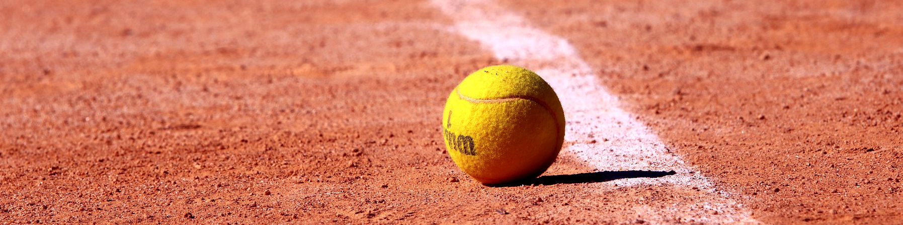 Bild: Tennisbald auf rotem Sandplatz